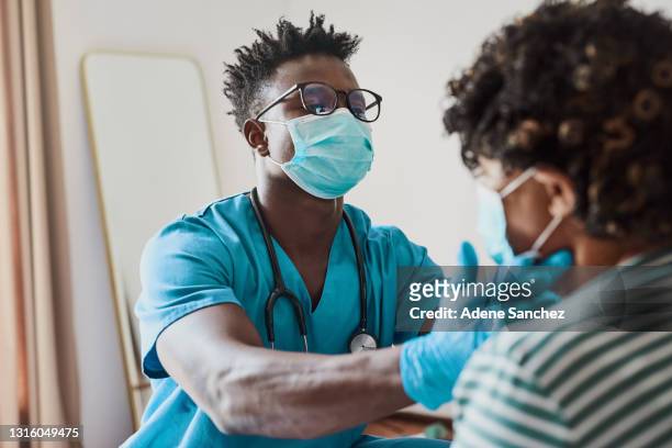 foto de una joven enfermera que trata a un paciente de edad avanzada en un asilo de ancianos - nurse with mask fotografías e imágenes de stock