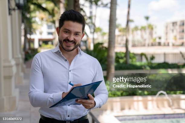 successful business man signing documents outdoors - door to door salesperson stock pictures, royalty-free photos & images