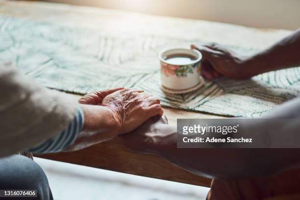 shot of two unrecognizable people sharing a cup of coffee - grief hands stock pictures, royalty-free photos & images