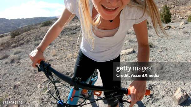 blick auf mountainbikerin lächelnd vor der kamera - adrenalin stock-fotos und bilder