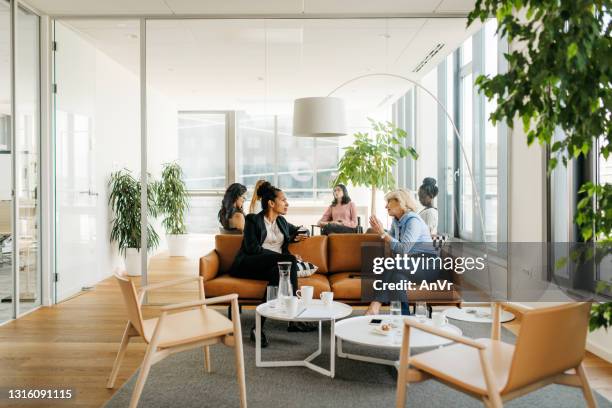 colegas femeninas en un descanso en una oficina moderna - cafe business fotografías e imágenes de stock