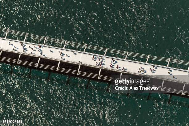 people walking on the millennium bridge in london - british culture walking ストックフォトと画像