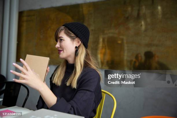 smiling businesswoman with product box sitting in creative office - prototype stock pictures, royalty-free photos & images