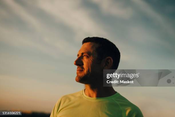 male athlete contemplating against sky during sunset - man look sky stock pictures, royalty-free photos & images