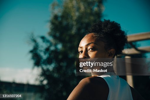 Portrait of female athlete looking over shoulder on sunny day Portrait of female athlete looking over shoulder on sunny day