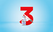 Syringe and COVID-19 Vaccine Bottle Sitting Next To A Huge Red Number Three Over Blue Background