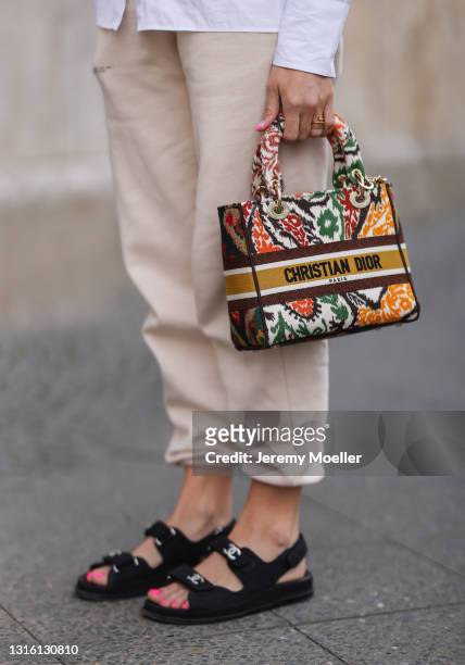 Sonia Lyson wearing white Uterque blouse, beige The Pangaia sweatpants, Lady Dior bag and black Chanel sandals on April 26, 2021 in Berlin, Germany.