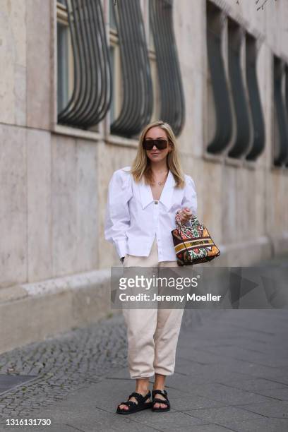 Sonia Lyson wearing white Uterque blouse, beige The Pangaia sweatpants, Lady Dior bag, Vera Wang shades and black Chanel sandals on April 26, 2021 in...