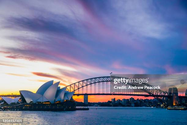 sydney opera house und sydney harbour bridge bei sonnenuntergang, new south wales, australien am 20. april 2021. - hafenbrücke von sydney stock-fotos und bilder