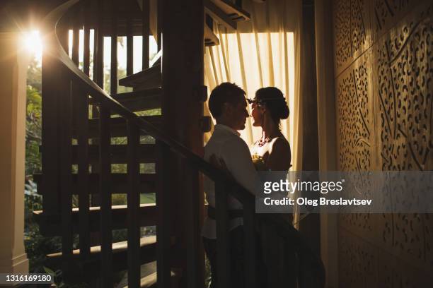 silhouette of sensual wedding couple in love in interior with beautiful warm sun light - couple lust stock pictures, royalty-free photos & images