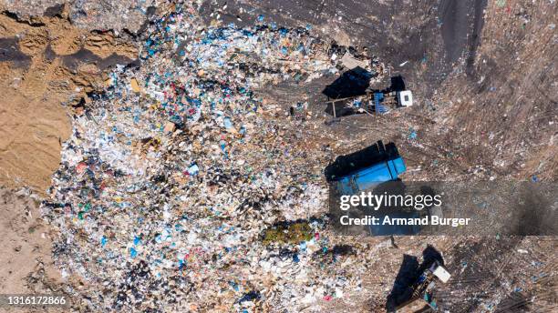 hochwinkelaufnahme von müllwagen auf einer deponie - landfill stock-fotos und bilder