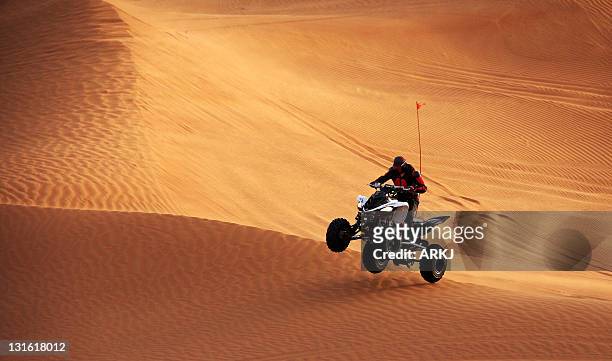 man riding quad bike - dubai desert stock-fotos und bilder