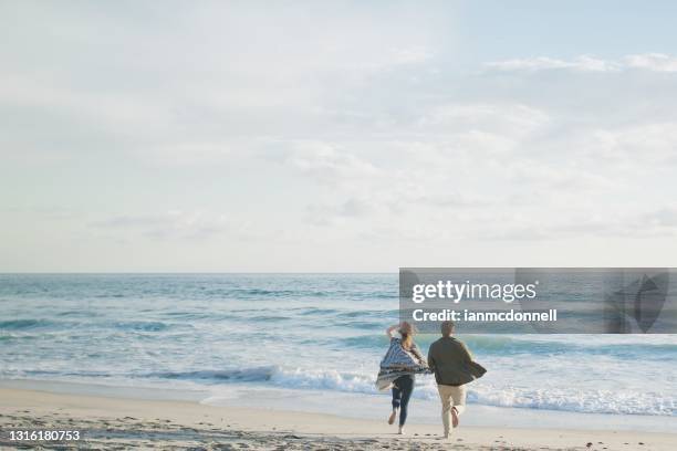 couple running on beach - carlsbad california stock pictures, royalty-free photos & images