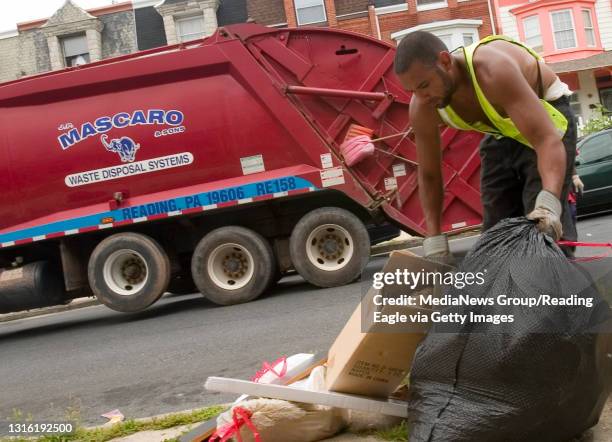 Reading - J.P. Mascaro & Sons employee Daniel Tuck prepares to haul trash to thetruck as it drives down the 200 block of N. Oley St. Where piles...