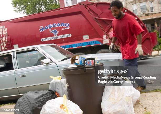 Reading - J.P. Mascaro & Sons employee Quinlin Williams prepares to haul trash to thetruck as it drives down the 200 block of N. Oley St. Where piles...