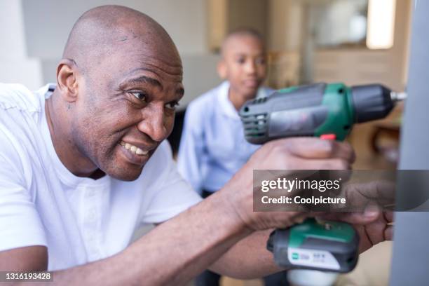 handy man with son using screwdriver. - easy task stock pictures, royalty-free photos & images