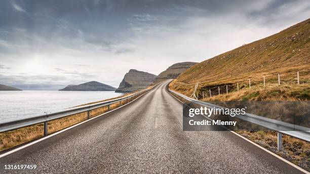 lonely coastal country road islas feroe panorama vidoy island - barrera de seguridad raya indicadora fotografías e imágenes de stock