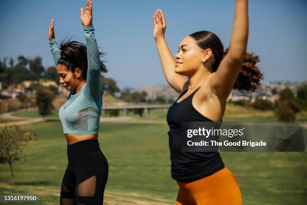 women doing jumping jacks at park - jumping jack stock pictures, royalty-free photos & images