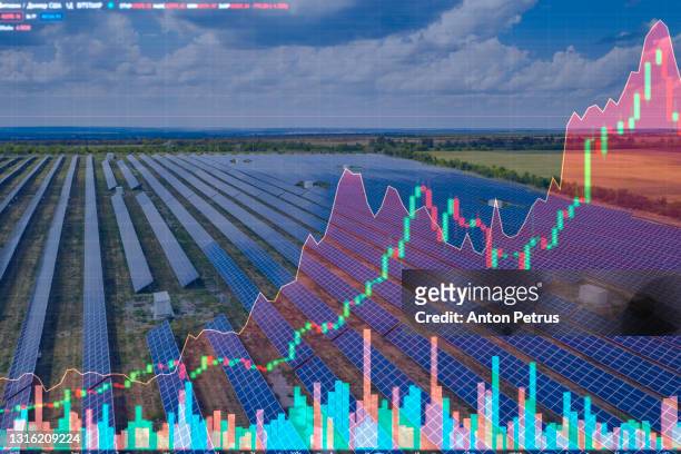 aerial view of the solar power station on the background of stock charts. alternative energy - finanza ed economia foto e immagini stock