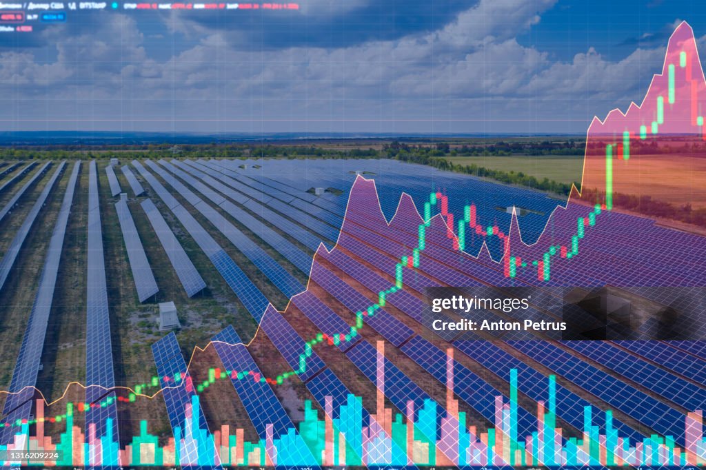 Aerial view of the solar power station on the background of stock charts. Alternative energy
