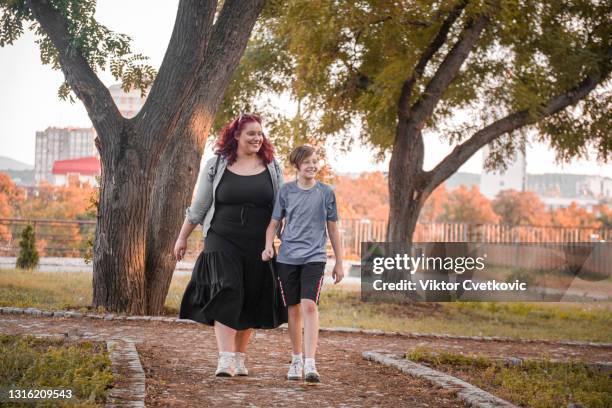 big sister and brother walking in the park - brother stock pictures, royalty-free photos & images