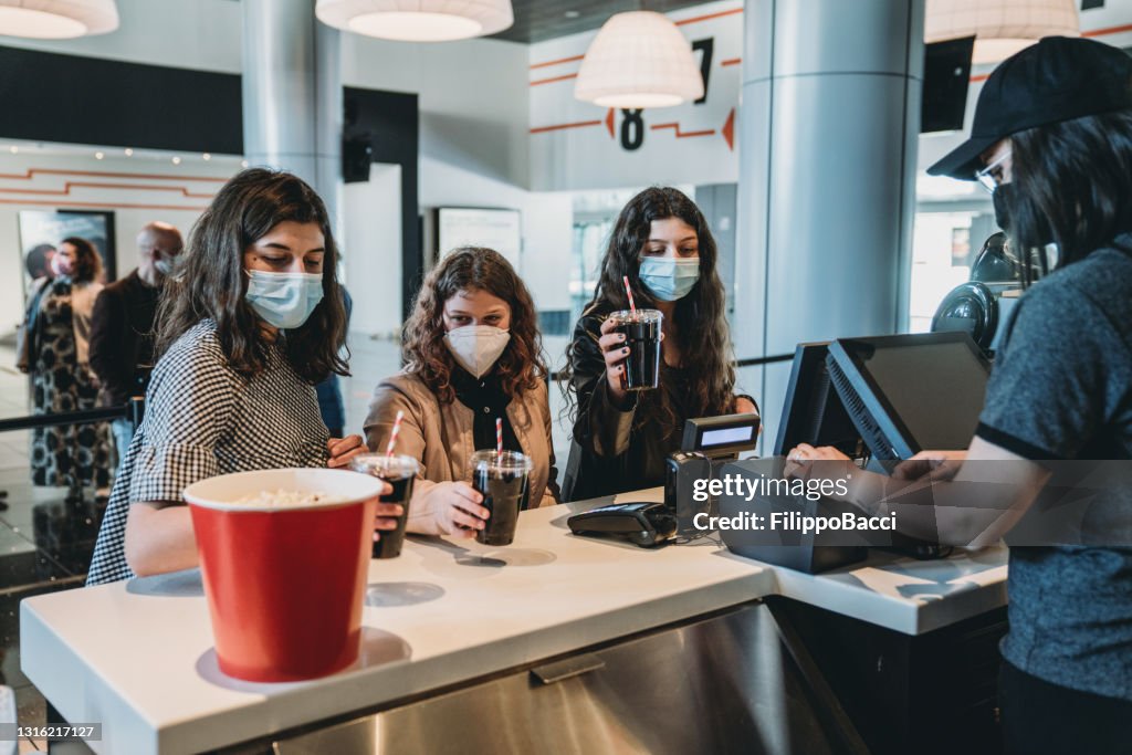 People are asking for drink and food at the movie theater's bar