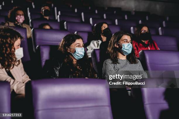 people watching a movie in a cinema during covid-19 coronavirus pandemic - spectator mask stock pictures, royalty-free photos & images