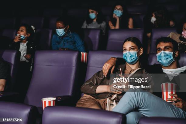 personas en una sala de cine durante la pandemia de coronavirus covid-19 - festival de film fotografías e imágenes de stock