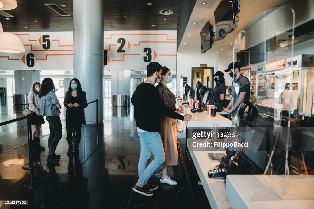 People are waiting in line at the movie theater's bar