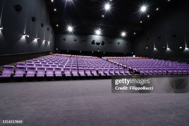 empty big movie theater hall with many rows of purple seats - large auditorium stock pictures, royalty-free photos & images