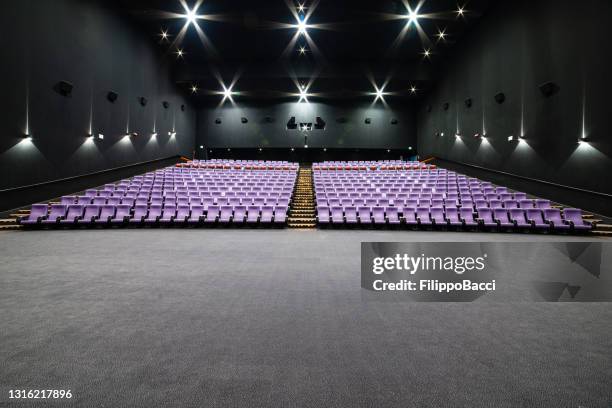 empty big movie theater hall with many rows of purple seats - large auditorium stock pictures, royalty-free photos & images