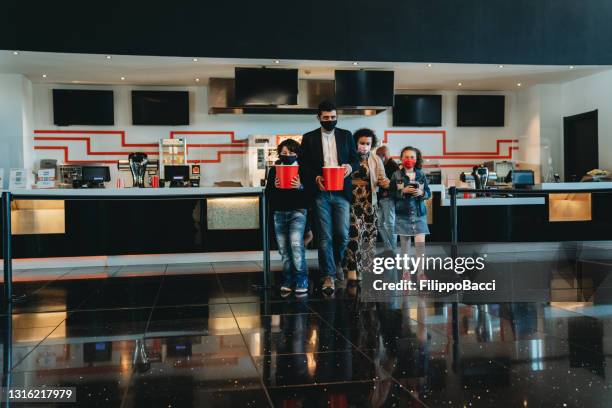 family at the movie theater bar is buying popcorn - bar reopening stock pictures, royalty-free photos & images