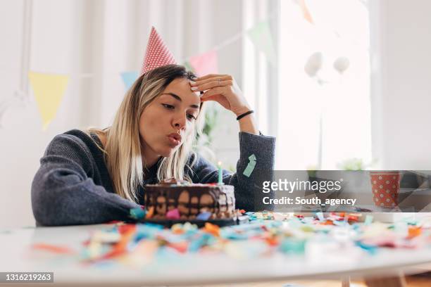 donna triste che soffia candele da sola - sad birthday foto e immagini stock