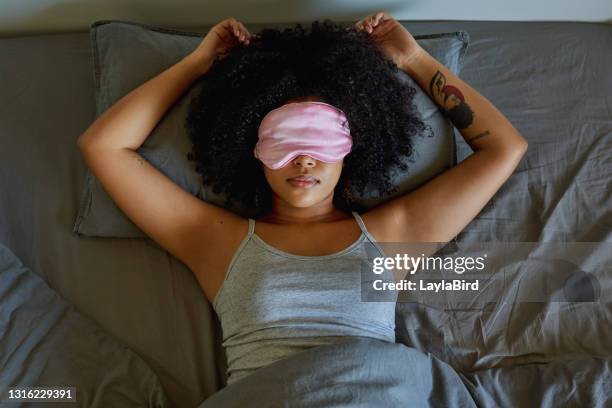 projectile d’une femme utilisant un masque de sommeil tout en se trouvant sur son bâti - masque pour les yeux photos et images de collection