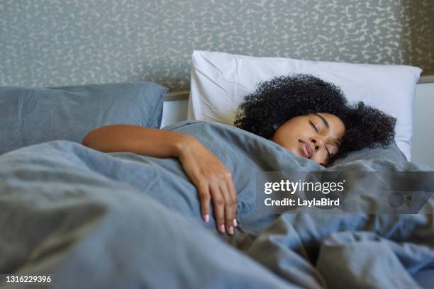 ontsproten van een jonge vrouwenslaap in haar bed thuis - pit stockfoto's en -beelden