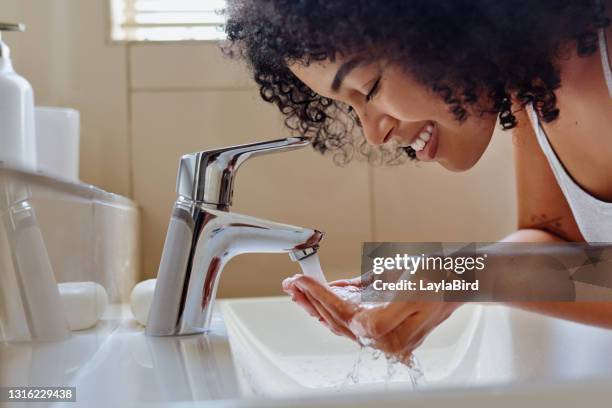 schuss einer schönen jungen frau waschen ihr gesicht im badezimmer - lady bird film stock-fotos und bilder