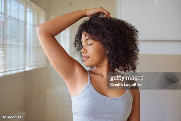 ontsproten van een mooie jonge vrouw die haar oksels thuis ruikt - oksel stockfoto's en -beelden