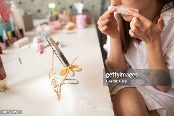 vrouw die zich voorbereidt om zich van ongewenst haar op haar bovenlip thuis te ontdoen - hars stockfoto's en -beelden