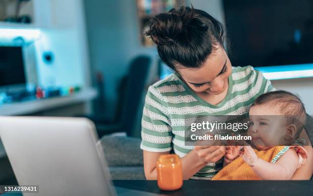 mother feeding her baby - baby food jar stock pictures, royalty-free photos & images