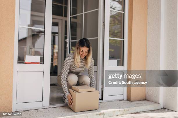donna che raccoglie il pacco - retrieving foto e immagini stock