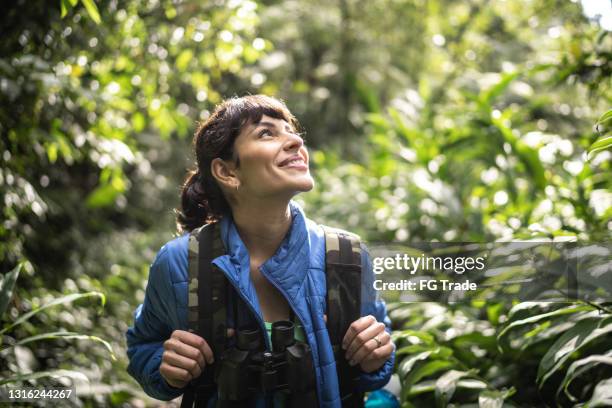 happy woman looking aroung while hiking in a forest - looking around stock pictures, royalty-free photos & images