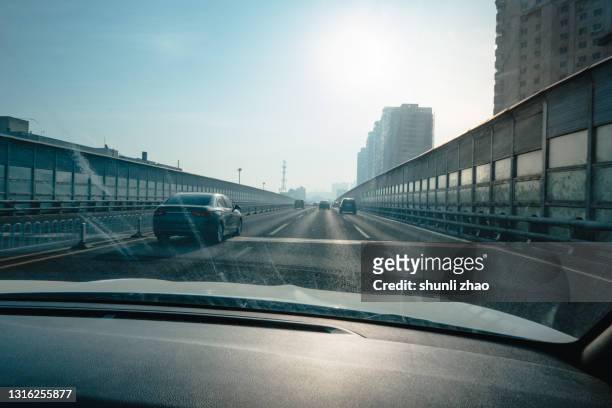 cars on fast road - フロントガラス ストックフォトと画像