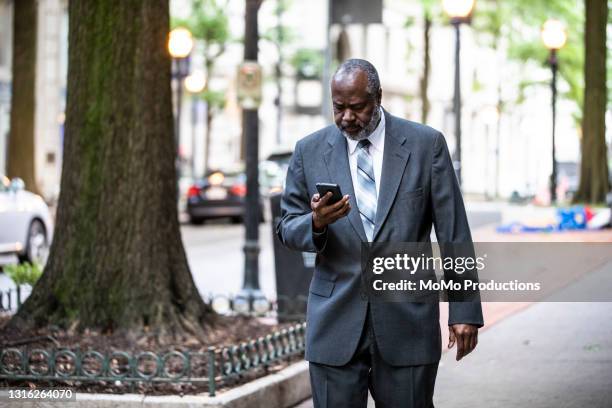 businessman using smartphone in downtown area - atlanta georgia map stock pictures, royalty-free photos & images