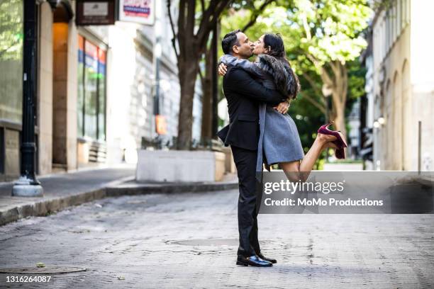 married couple kissing in downtown area on a date - kissing mouth stock pictures, royalty-free photos & images