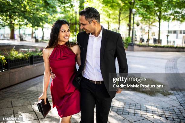 married couple strolling through downtown park - festlich gekleidet stock-fotos und bilder