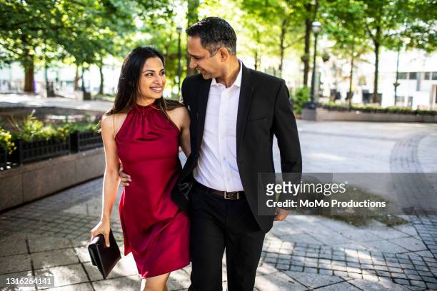 married couple strolling through downtown park - abbigliamento formale foto e immagini stock