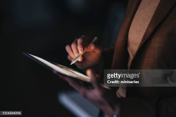 hombre de cultivo con lápiz óptico usando tableta para trabajar por la noche - bolígrafo digitalizado fotografías e imágenes de stock