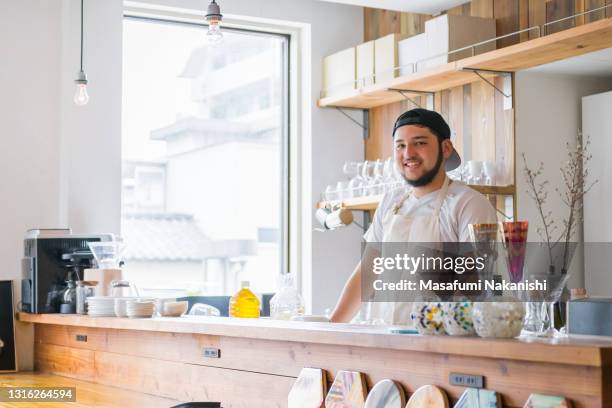 asian small business owner stand in bar counter of his nice cafe - café bar 個照片及圖片檔