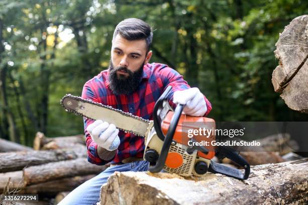 lumberjack checking his chainsaw - man with chainsaw stock pictures, royalty-free photos & images