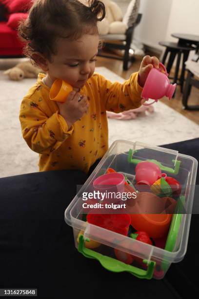 het meisje dat van de baby met haar plastic speelgoed speelt - lesseps stockfoto's en -beelden